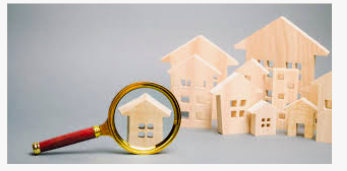 Small wooden houses with a magnifying glass over one